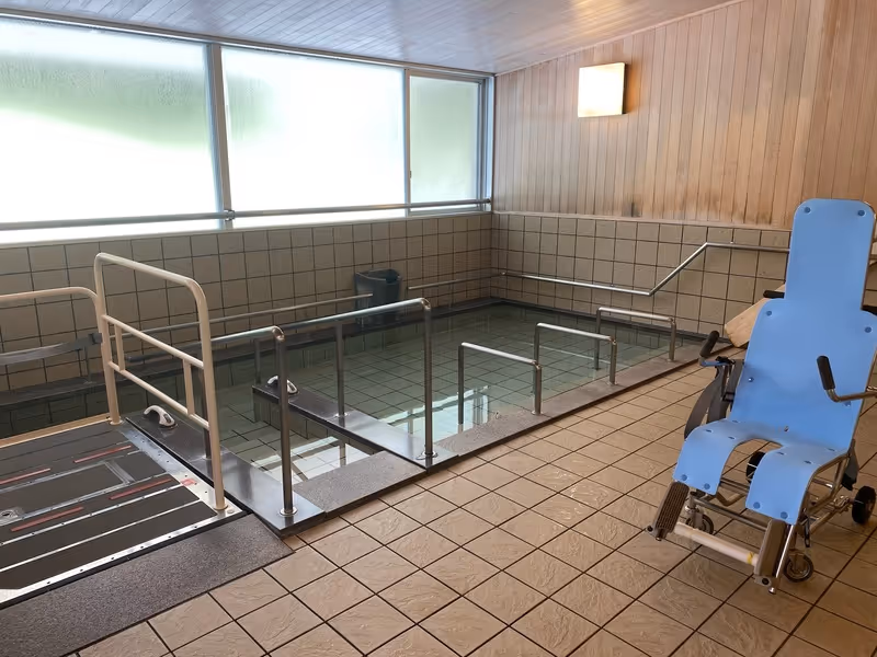 湯花里苑の広々とした浴室。階段手すり付き浴槽で温泉気分を楽しめる